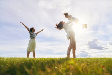 Yaz yürüyüşündeki mutlu aile! Anne ve kızları parkta yürüyor ve güzel doğanın tadını çıkarıyorlar..                                