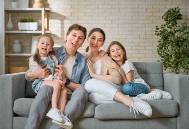 Mutlu aile! Anne ve babadan iki kız çocuğu. Annem, babam ve kızlar gülüyor ve sarılıyorlar..                                