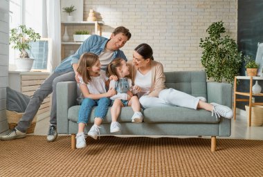 Mutlu aile! Anne ve babadan iki kız çocuğu. Annem, babam ve kızlar gülüyor ve sarılıyorlar..                                