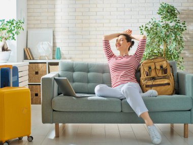 Bir maceraya git! Mutlu kadın yolculuk için hazırlanıyor. Bavul ile genç kişi.