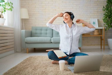 Evde dizüstü bilgisayarda çalışan mutlu ve güzel bir kadın..