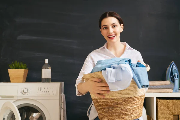 Όμορφη Νεαρή Γυναίκα Χαμογελάει Ενώ Πλένει Ρούχα Στο Σπίτι — Φωτογραφία Αρχείου