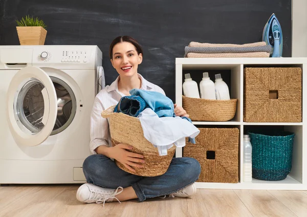 Hermosa Joven Mujer Sonríe Mientras Hace Colada Casa — Foto de Stock