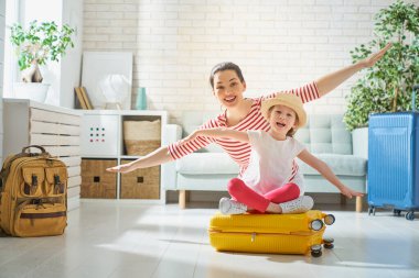 Bir maceraya git! Mutlu bir aile yolculuk için hazırlanıyor. Anne ve kızı bavul seyahat için ambalaj.                               