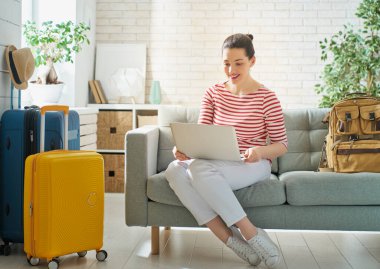 Bir maceraya git! Mutlu kadın yolculuk için hazırlanıyor. Bavul ile genç kişi.