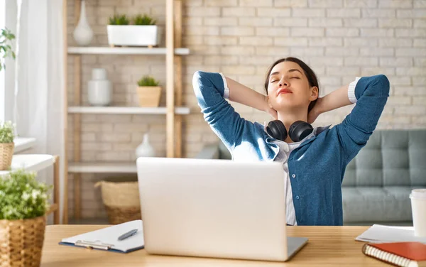 Evde dizüstü bilgisayarda çalışan mutlu ve güzel bir kadın..                                