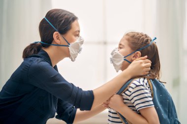 Anne ve çocuk koronavirüs ve grip salgını sırasında maske takıyor. Virüs ve hastalık koruması, evde eğitim ve karantina. COVID-2019