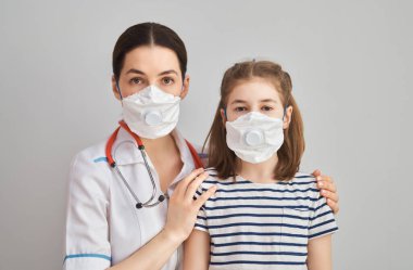 Doktor ve çocuk koronavirüs ve grip salgını sırasında maske takıyor. Virüs ve hastalık koruması, evde eğitim ve karantina. COVID-2019                               