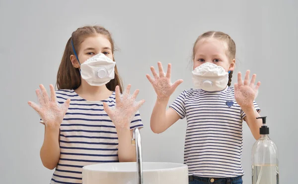 Girls are wearing face masks and washing their hands during coronavirus and flu outbreak. Virus and illness protection, home education and quarantine. COVID-2019