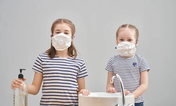 女の子達は 顔のマスクをつけており コロナウイルスとインフルエンザの発生の間 自分達の手を洗っています ウイルスや病気の保護 家庭教育や隔離 Covid 2019 — ストック写真