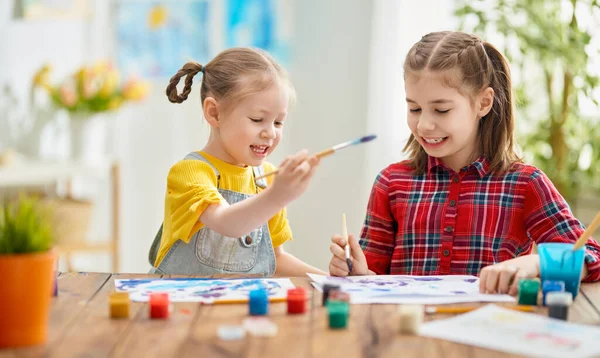 快乐的孩子们在家里画画 女孩子们坐在桌子旁边做着创造性的工作 — 图库照片