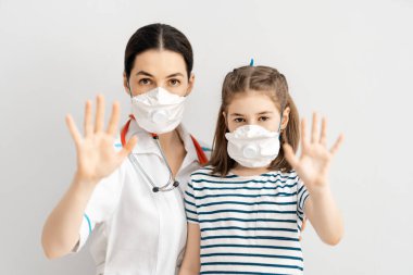 Doktor ve çocuk koronavirüs ve grip salgını sırasında maske takıyor. Virüs ve hastalık koruması, evde eğitim ve karantina. COVID-2019