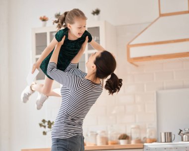 Anneler Günün kutlu olsun! Çocuk kızı annemi tebrik ediyor ve ona kartpostal veriyor. Anne ve kız gülümsüyor ve sarılıyorlar. Aile tatili ve birliktelik.                                