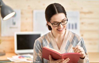 Evde dizüstü bilgisayarda çalışan mutlu ve güzel bir kadın..                                  