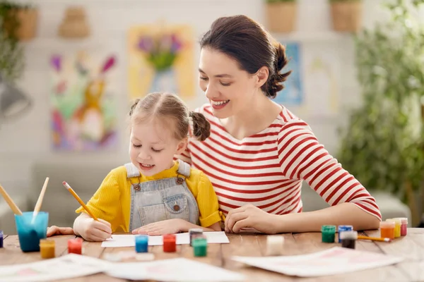 幸せな家族だ 母と娘が一緒に絵を描く 子供の女の子を助ける大人の女性 — ストック写真