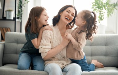 Anneler Günün kutlu olsun! Anne ve kızları oynuyorlar, gülüyorlar ve sarılıyorlar. Aile tatili ve birliktelik.                                 