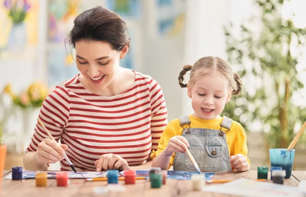 幸せな家族だ 母と娘が一緒に絵を描く 子供の女の子を助ける大人の女性 — ストック写真