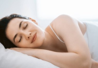 Güzel genç bayan yatak odasında uyuyor.