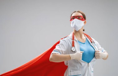 Koronavirüs salgını sırasında maskeli ve süper kahraman pelerinli bir doktor. Virüs ve hastalık koruması, karantina. COVID-2019. Tıbbın süper kahraman gücü..