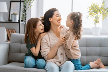 Anneler Günün kutlu olsun! Anne ve kızları oynuyorlar, gülüyorlar ve sarılıyorlar. Aile tatili ve birliktelik.  