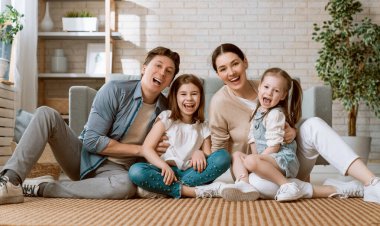 Mutlu aile! Anne ve babadan iki kız çocuğu. Annem, babam ve kızlar gülüyor ve sarılıyorlar..