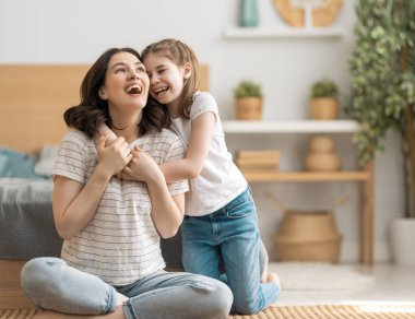 Güzel bir kız bebek ve annesi güneşli bir sabahın tadını çıkarıyorlar. Evde iyi vakit geçir.. 