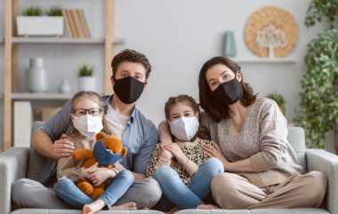 Ailesi koronavirüs ve grip salgını sırasında maske takıyor. Virüs ve hastalık koruması, karantina. COVID-2019. Evde kalmam için bir çağrı.