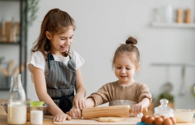Mutlu sevgi dolu aile birlikte fırın hazırlanıyor. Çocuklar kız kurabiye pişirme ve mutfakta eğleniyor. Ev yapımı yemekler ve küçük yardımcılar. 