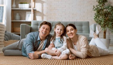 Mutlu aile! Annesi ve babası olan bir kız çocuğu. Anne, baba ve kız gülüyor ve sarılıyorlar.. 