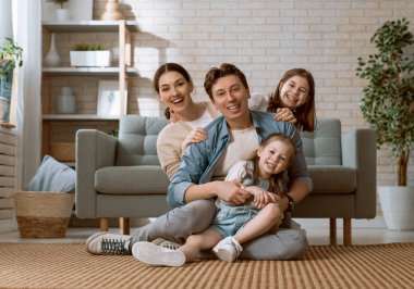 Mutlu aile! Anne ve babadan iki kız çocuğu. Annem, babam ve kızlar gülüyor ve sarılıyorlar..