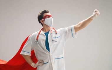 Koronavirüs salgını sırasında maskeli ve süper kahraman pelerinli bir doktor. Virüs ve hastalık koruması, karantina. COVID-2019. Tıbbın süper kahraman gücü..