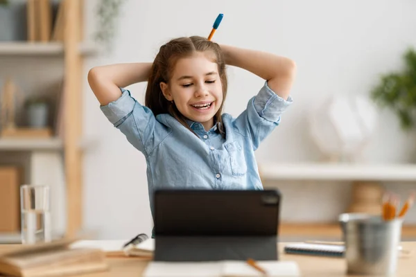 学校に戻る 幸せな子供が机に座っている 宿題やオンライン教育をする女の子 — ストック写真