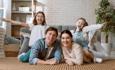 Mutlu aile! Anne ve babadan iki kız çocuğu. Annem, babam ve kızlar gülüyor ve sarılıyorlar..
