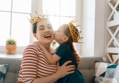 Sevgi dolu bir aile. Anne ve kızı evde oynaşıp sarılıyorlar..