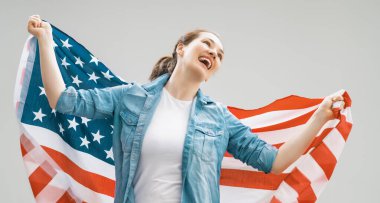Vatansever bayram. Amerikan bayrağı taşıyan mutlu genç bir kadın. ABD 4 Temmuz 'u kutladı.