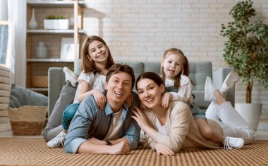 Mutlu aile! Anne ve babadan iki kız çocuğu. Annem, babam ve kızlar gülüyor ve sarılıyorlar..