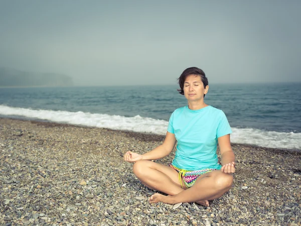 Mujer meditando en la orilla del mar —  Fotos de Stock