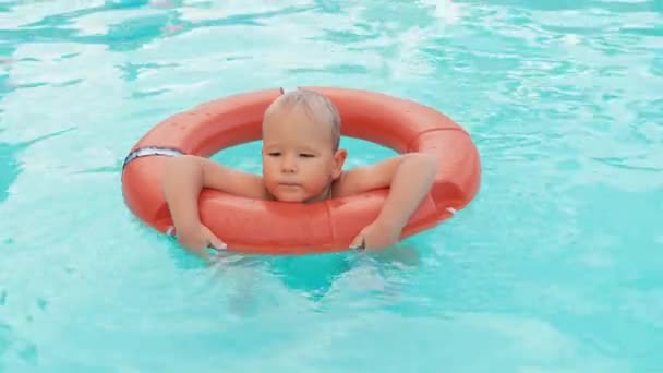 Мальчик играет в бассейне с спасательным буем — стоковое видео