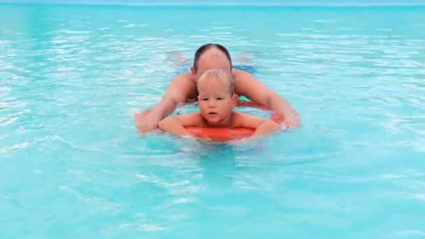 Pojke och far leker i poolen — Stockvideo