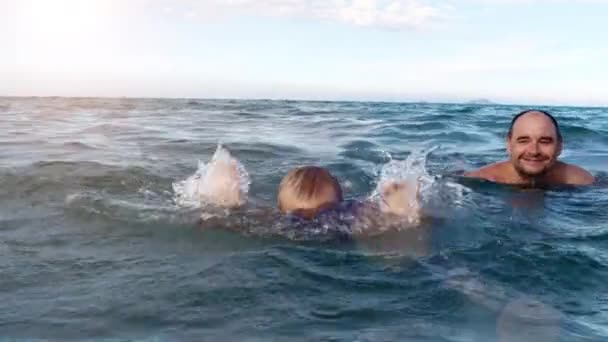 Boy and father swim in the sea slow motion — Stock Video