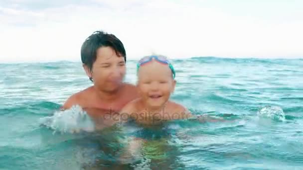 Счастливый мальчик делает рывок в море замедленным движением — стоковое видео