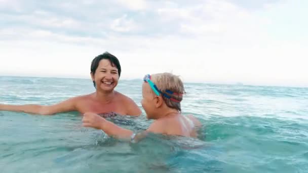 Feliz hijo y madre sonriendo, jugando con tabla de natación cámara lenta — Vídeo de stock