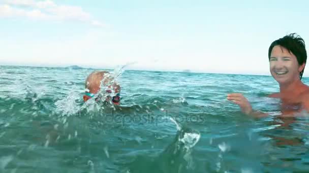 Niño y madre juega con la pelota en el mar cámara lenta — Vídeos de Stock