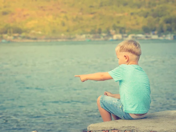 Deniz kenarında işaret eden sevimli beyaz çocuk — Stok fotoğraf