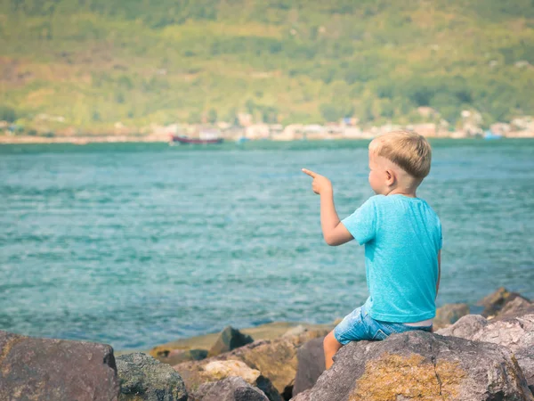 Bonito menino caucasiano apontando para o litoral — Fotografia de Stock
