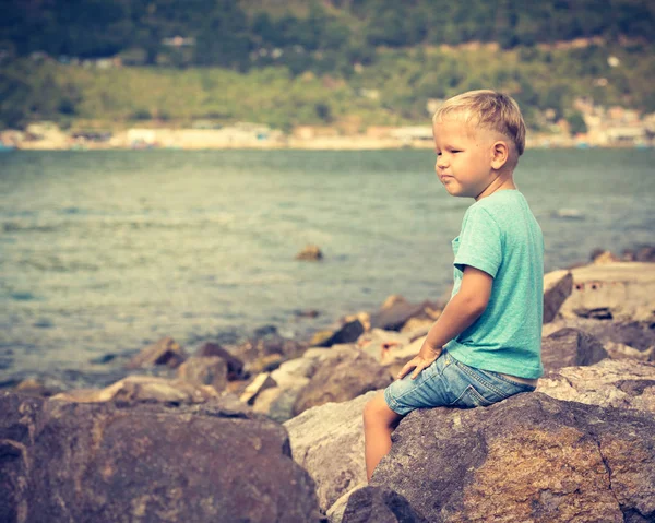 Leuke blanke jongen zitten aan zee — Stockfoto