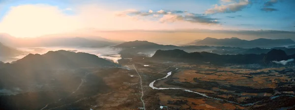 Vista aérea de un pequeño pueblo en el valle rocoso de la montaña y el río —  Fotos de Stock