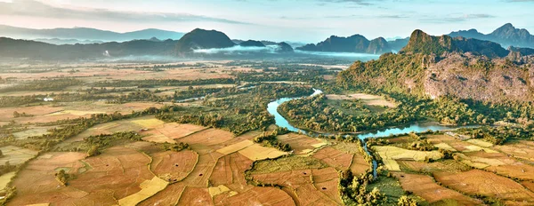 Vista aérea de um campo de arroz no vale de montanha rochosa e rio — Fotografia de Stock