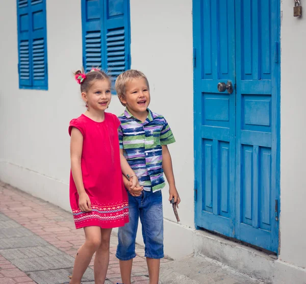 走在大街上的孩子们 紧挨着蓝色的百叶窗 — 图库照片