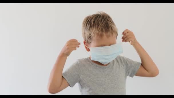 男孩戴着面部一次性口罩以避免病毒感染 停止结肠病毒 — 图库视频影像